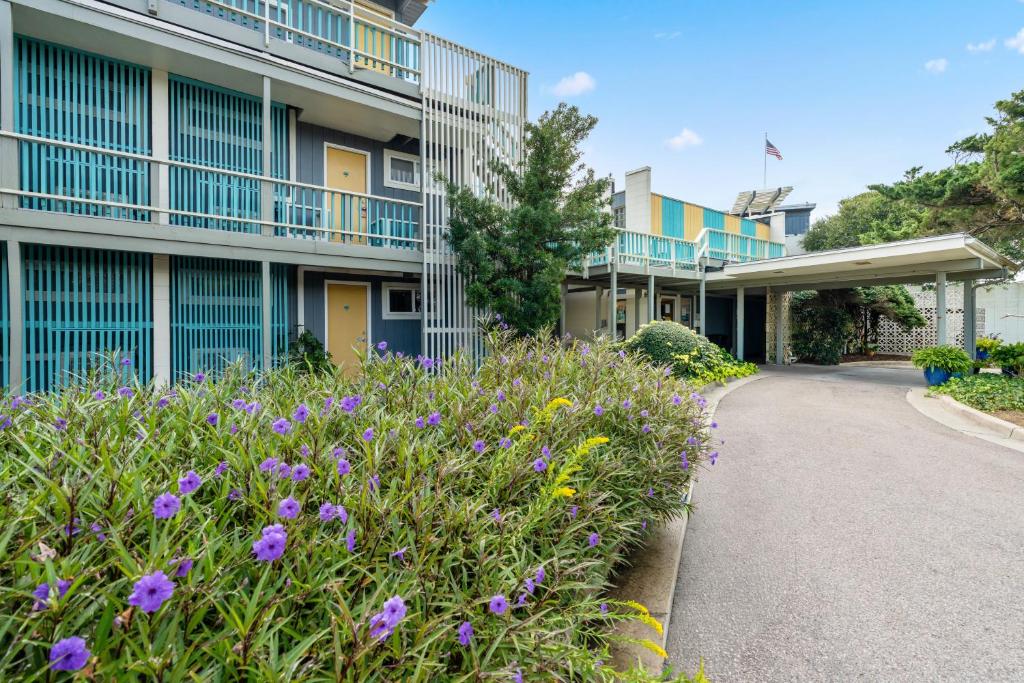 una passerella di fronte a un edificio con fiori viola di Atlantis Lodge a Pine Knoll Shores