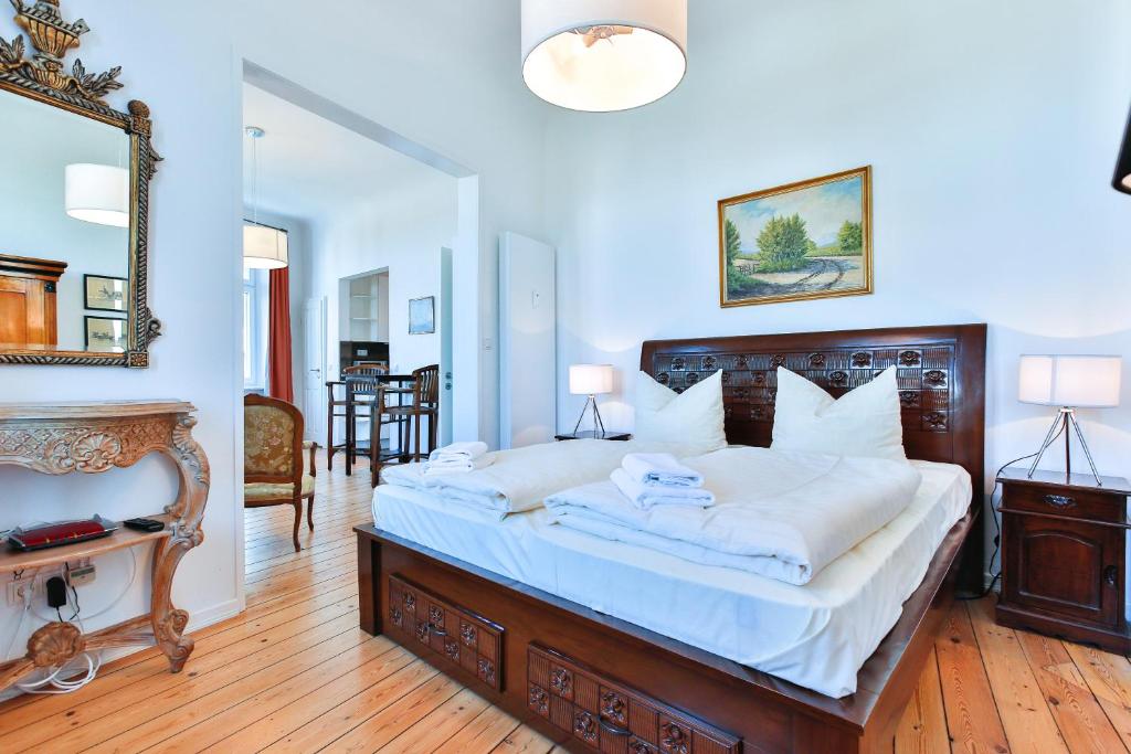 a bedroom with a large bed with white sheets at Riverside Apartments in Lübeck