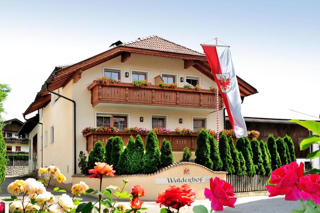 a building with a flag and flowers in front of it at Apartment Walder in Fiumes