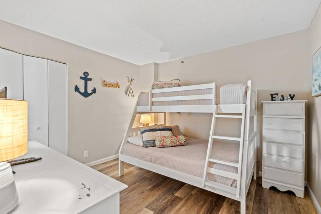 ein Schlafzimmer mit Etagenbett und Schreibtisch in der Unterkunft Atlantic Dunes Resort Unit 502 with Direct Oceanfront Balcony in Myrtle Beach