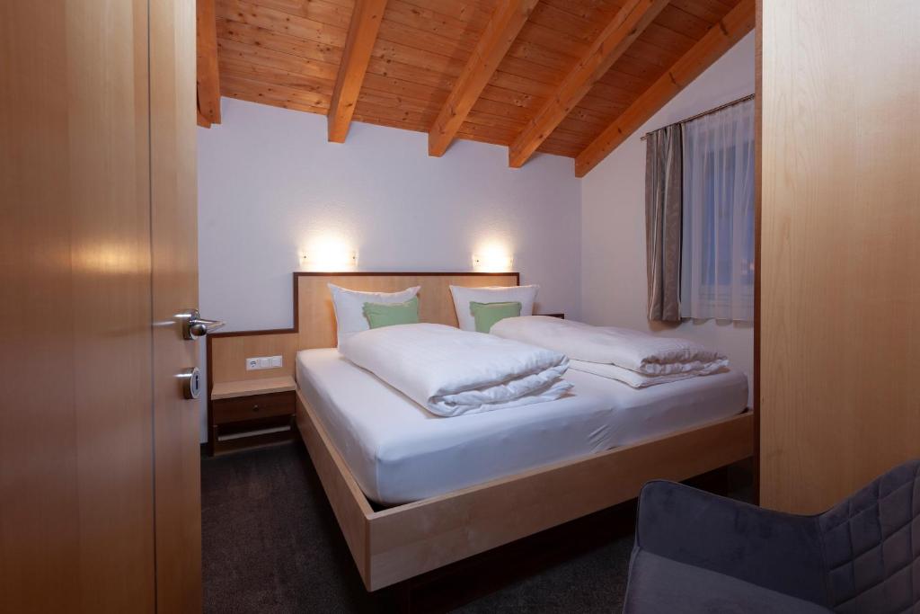 two twin beds in a room with a door at Alpina Appartements in Nauders