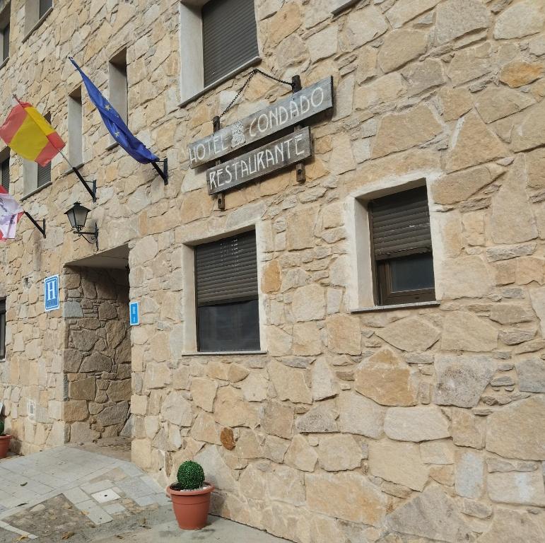 米兰达德尔卡斯塔尼亚尔Hotel Condado de Miranda的一座带有路牌的石头建筑