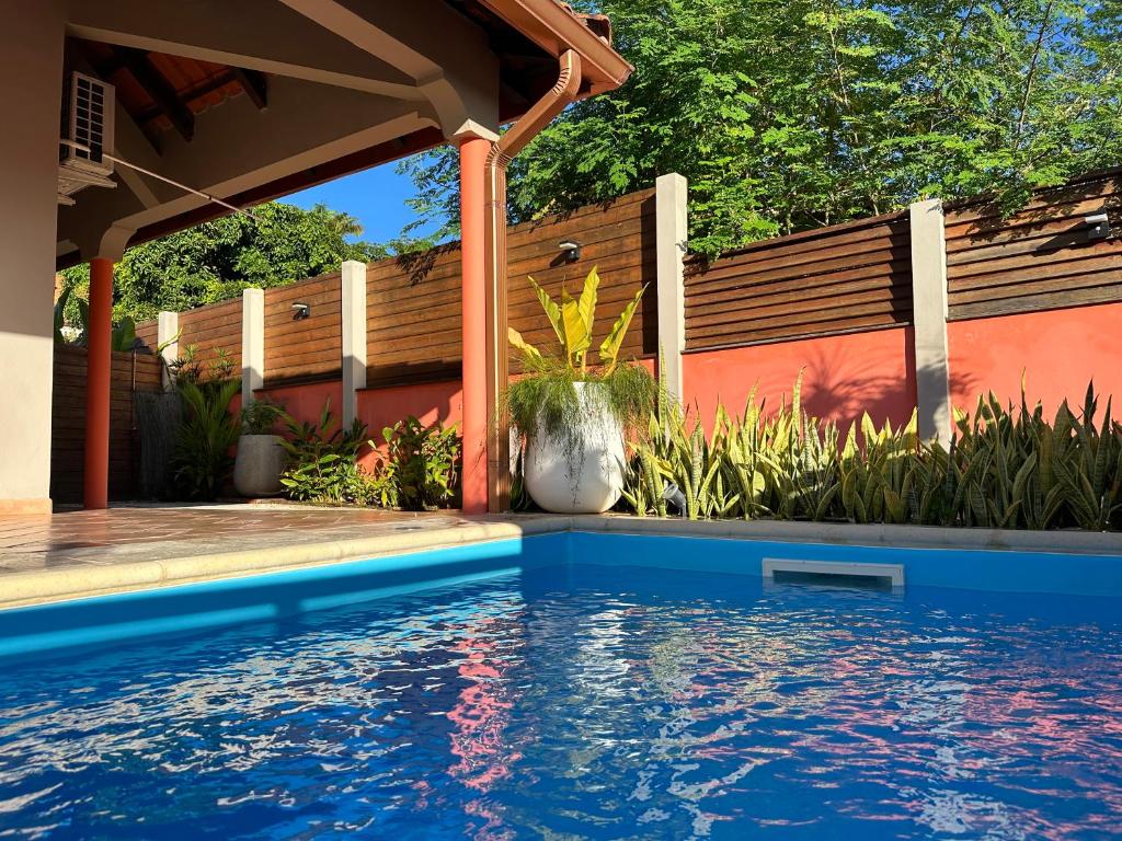 a swimming pool in a backyard with a wooden fence at Maison de vacance 2 Chambres à 200m de la plage in Sainte-Anne