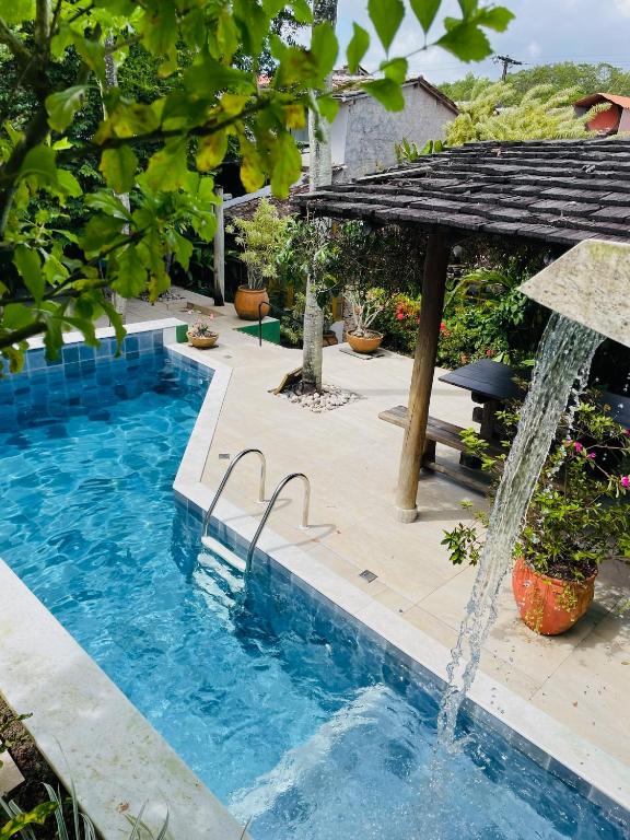 a swimming pool with a water fountain at Hotel Estalagem Porto Seguro in Porto Seguro