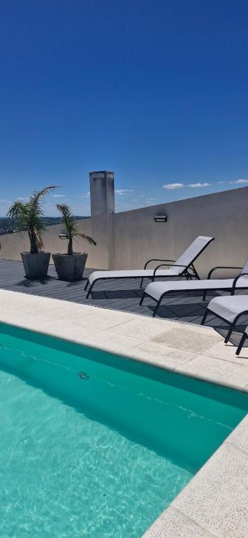 a swimming pool with lounge chairs next to the beach at PARANA Parque y CPC in Paraná