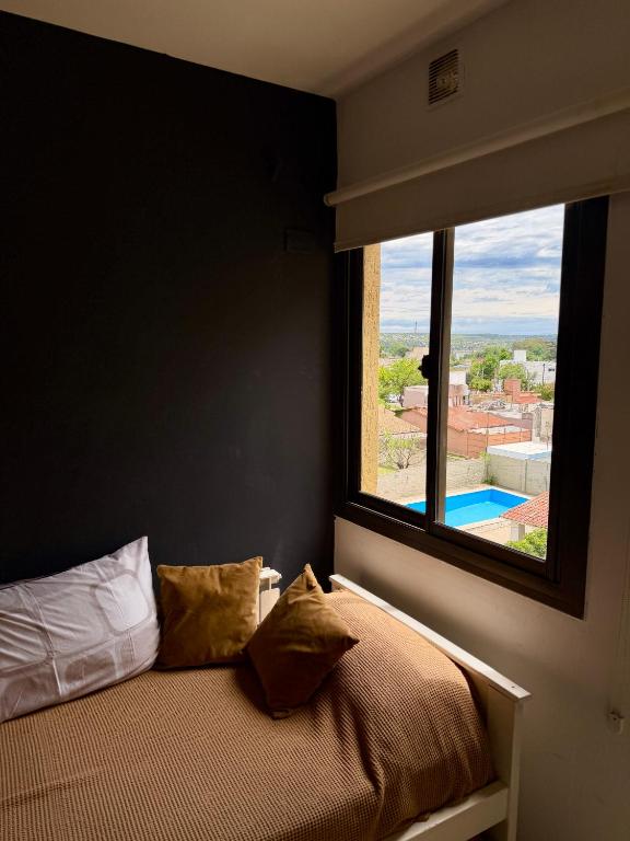 a bedroom with a bed and a window with a view at Departamento en el corazón de Villa Carlos Paz in Villa Carlos Paz