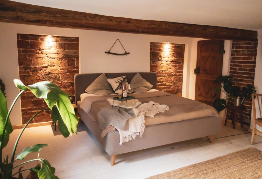a bedroom with a bed and a brick wall at Klinkerstube in Heuchelheim-Klingen