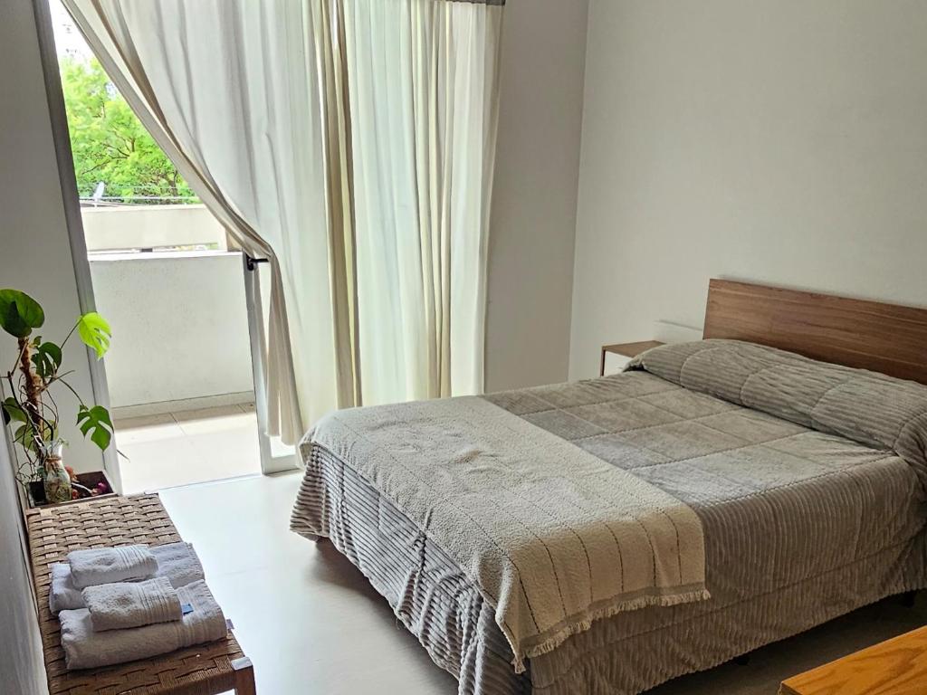 Un dormitorio con una cama y una ventana grande. en PARANA Parque y CPC, en Paraná