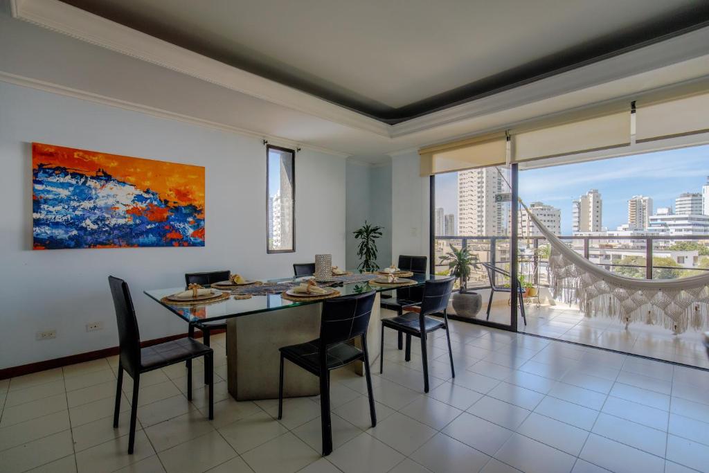 a dining room with a table and chairs and a large window at Habitación doble baño privado cerca al mar y bahia in Cartagena de Indias