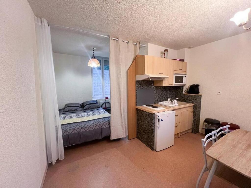 ein kleines Zimmer mit einer kleinen Küche und einem Bett in der Unterkunft le primo - Château - Ville in Château-Chinon