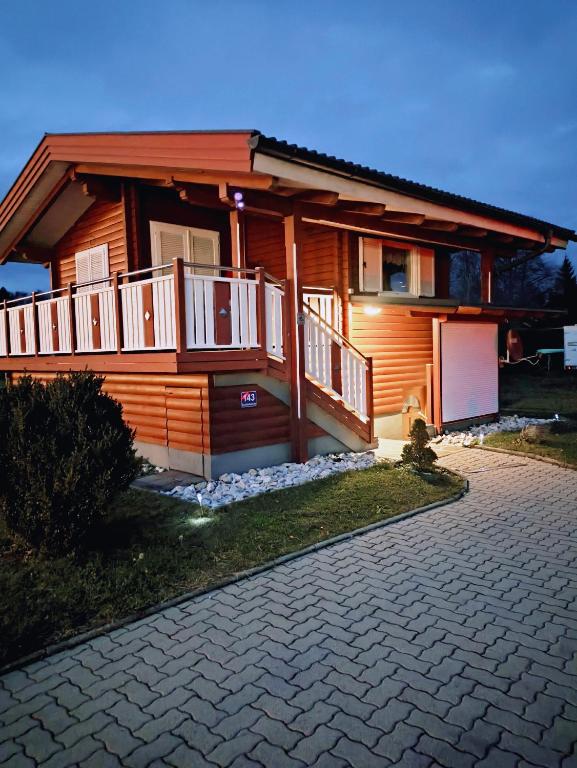 a house with a balcony and a driveway at Ferienhaus LiRa in Drobollach am Faaker See