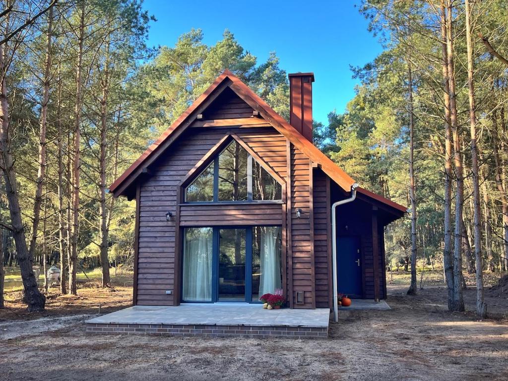 een kleine hut in het bos met bomen bij Whispering Woods Cabin in Milicz