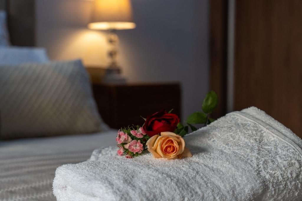 a bouquet of flowers sitting on top of a bed at Appartement Moderne Poolside Gueliz centre Sun PS4 & Wi-Fi in Marrakesh