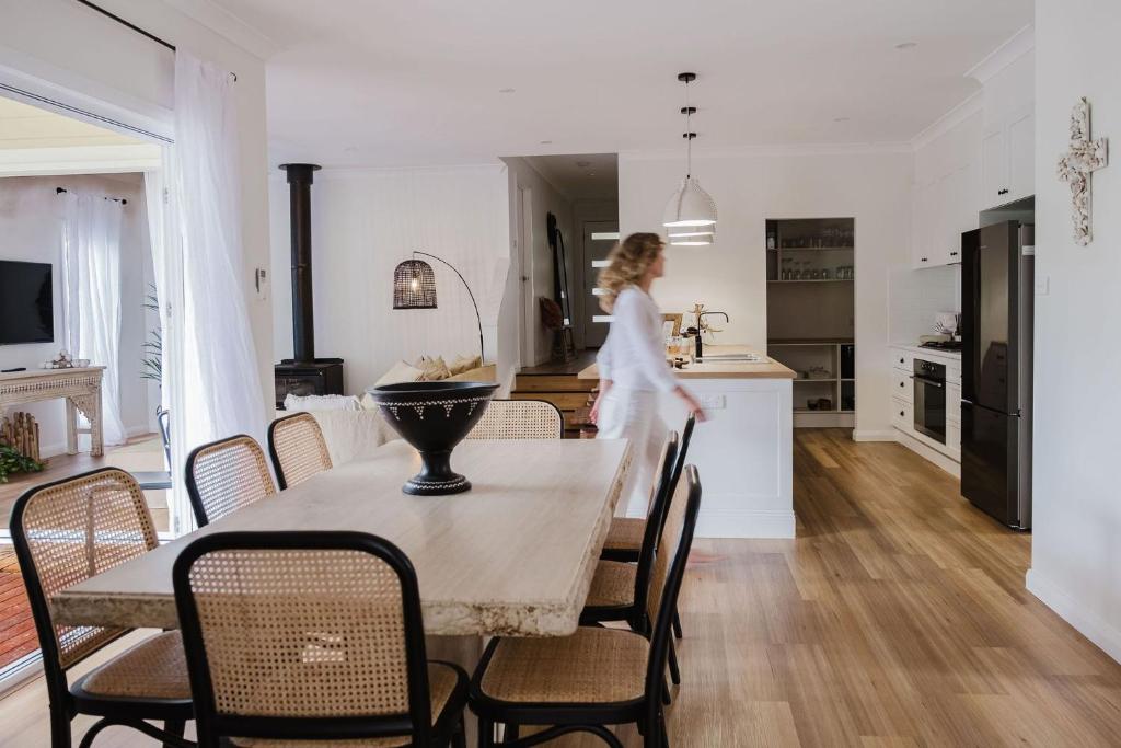 a woman is walking through a kitchen and dining room at The Lake Escape in Yatte Yattah