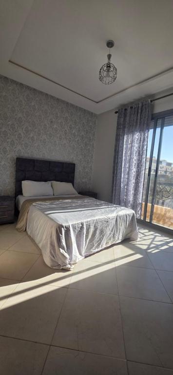 um quarto com uma cama e uma janela grande em luxury apartment DT2 em Mohammedia