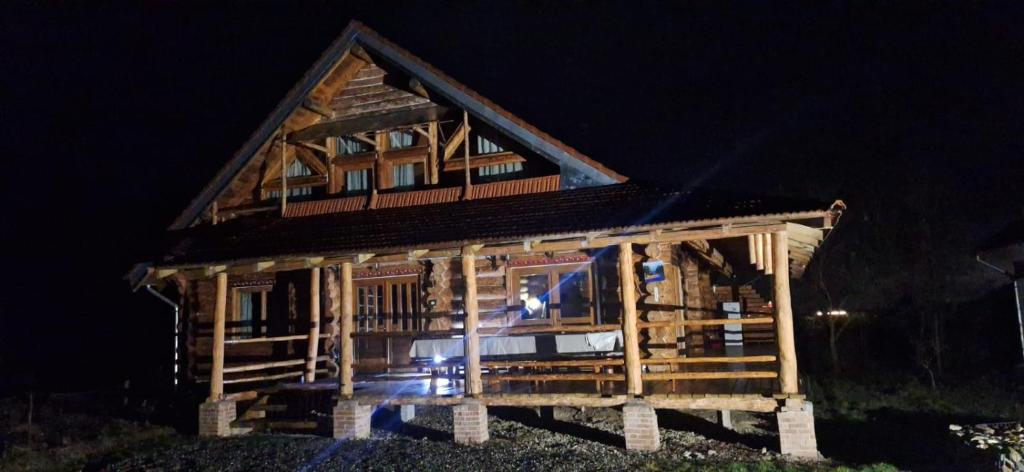 a wooden house with people standing in front of it at Farmhouse Rosehip Flower Romania Brasov in Râşnov
