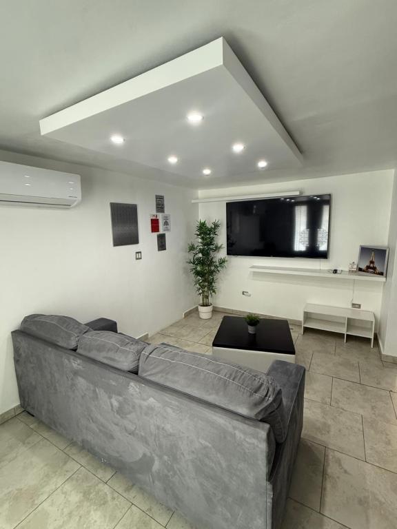 a living room with a couch and a tv at Red House - Modern 2BR Near isla verde & Airport in Carolina