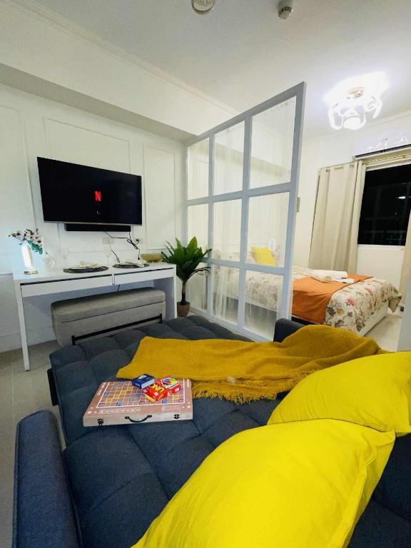 a living room with a blue couch and a television at ASV Condo Staycation SMDC Breeze in Manila