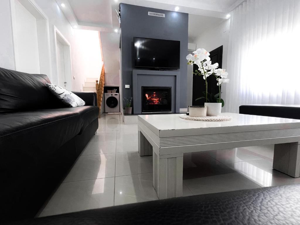 a living room with a couch and a table with a fireplace at Casa Di SI in Përmet