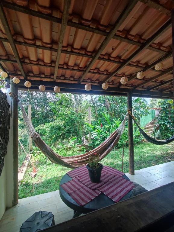 a hammock with a table and a potted plant on a patio at Loft Iemanjá in Itacaré