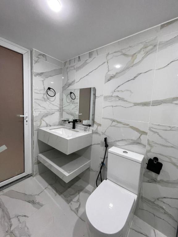 a bathroom with a white toilet and a sink at Spirit of the Badia camp in Disah