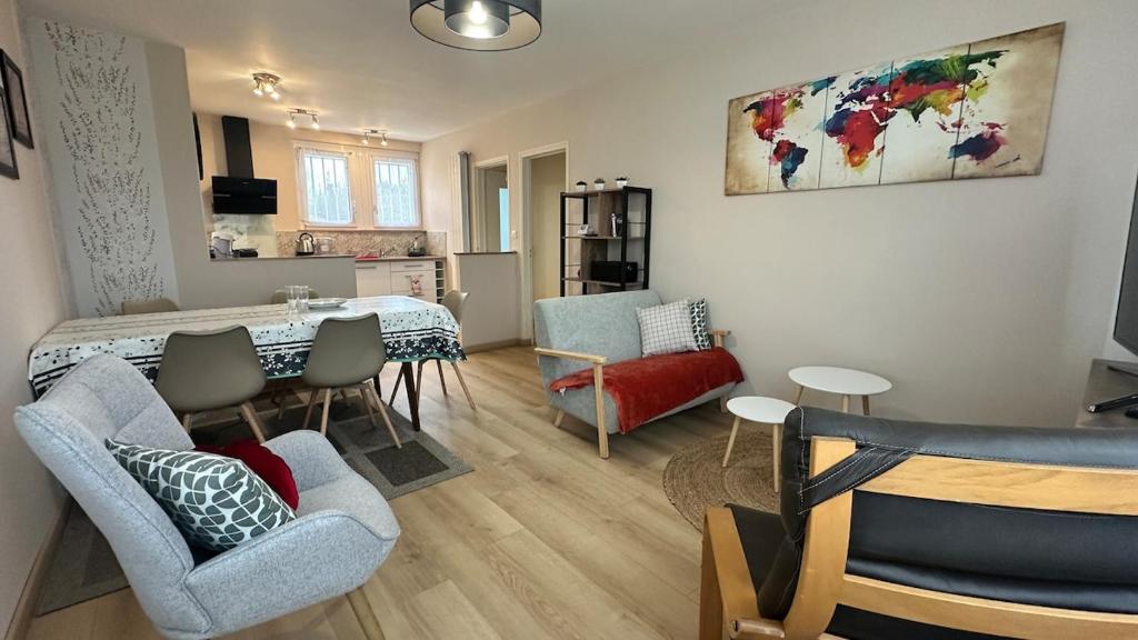 Una sala de estar con mesa y sillas y una cocina. en 3 bedroom house for 5 people, en Rochefort