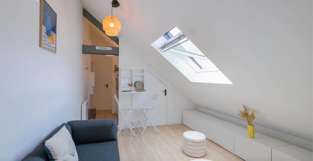 a living room with a blue couch and a window at Le Perchoir du marché - Appartement pour 2 personnes in Saint-Nazaire