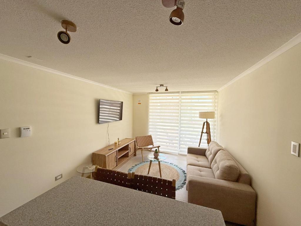 una sala de estar con un sofá y una mesa en Jardines del Pacífico IV, en La Serena