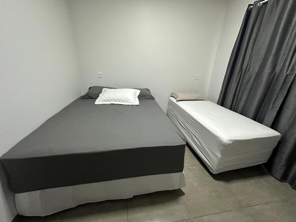 un dormitorio con dos camas en una habitación en Casa vaga 2 carros ou caminhonete, 2 quartos, espaçosa, completa para 8 pessoas, en Sinop