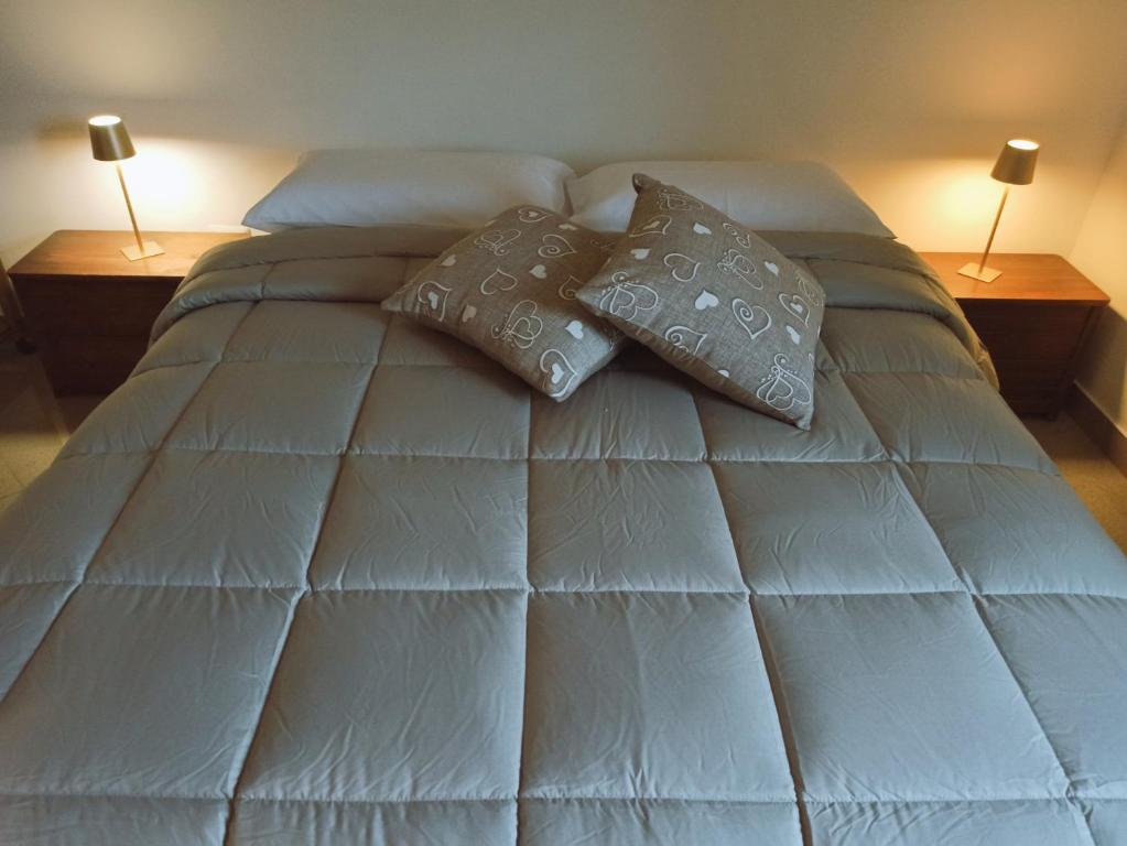 un letto con due cuscini sopra e due lampade di Marisella holidays house a Pozzuoli