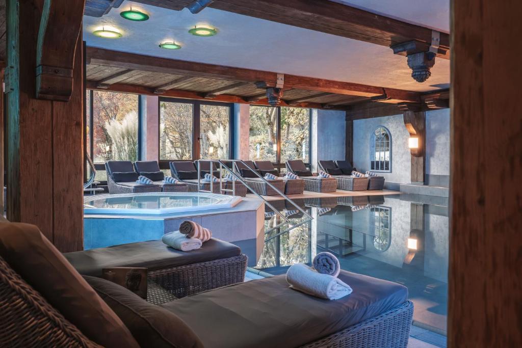 a room with a swimming pool and a pool house at Alpin & Wellness Resort Ludwig Royal in Oberstaufen