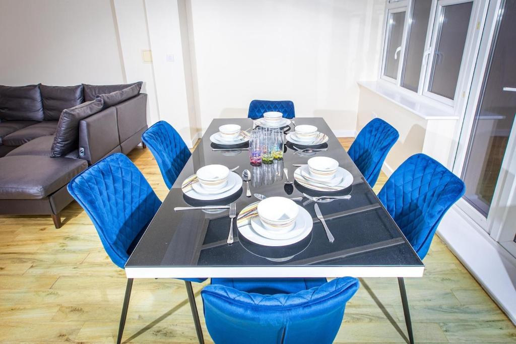 una sala da pranzo con un tavolo e sedie blu di Stunning 5 Bed Home in Maidstone a Snodland