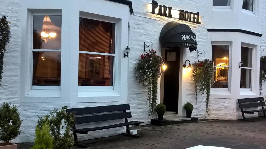 een wit gebouw met een bank ervoor bij The Park Hotel in Dunoon