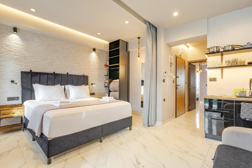 a bedroom with a large bed and a bathroom at Melina's - Urban Luxury 2BR 2Bath 2Balcony Apt - Heart of Chania, Private Parking Available 800m in Chania