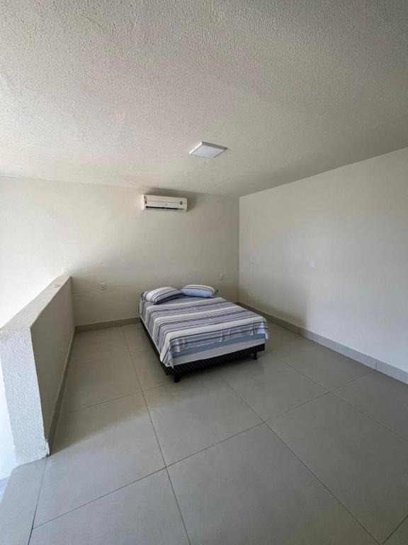 a bedroom with a bed in the corner of a room at Loft do Valle II in Sorriso