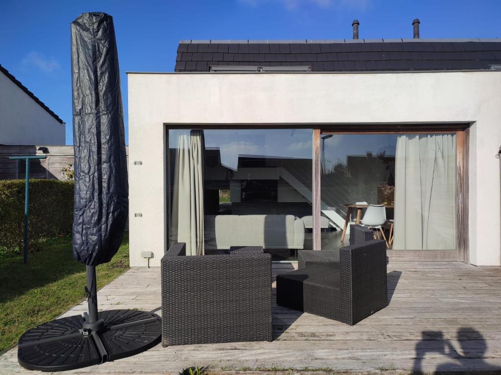 a patio with a table and chairs and a building at Zanderover in Koksijde