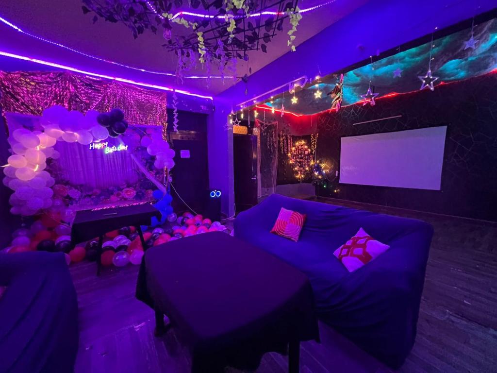 Habitación púrpura con sofá y TV en Dim delights, en Nueva Delhi