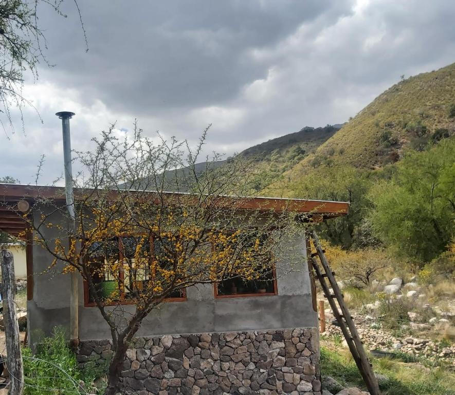 una casa de piedra con una montaña en el fondo en Pie de Sierra, en Los Hornillos