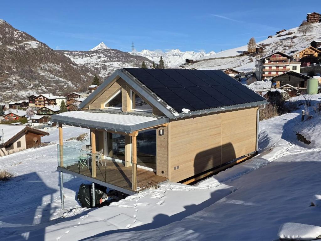 ein Haus mit Solardach im Schnee in der Unterkunft Tiny Barrhorn in Grächen