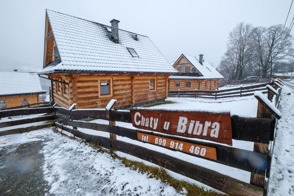 a log cabin in the snow with a sign in front at Chaty u Bibra in Sablówka