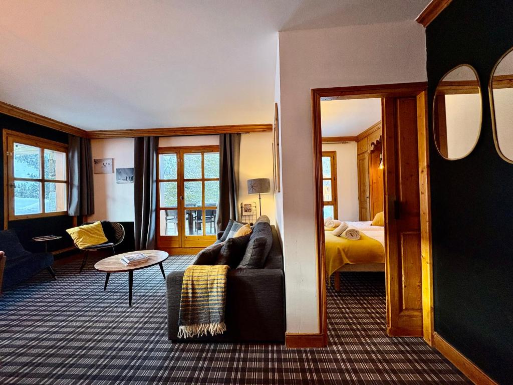 un soggiorno con un divano e un letto di Appartement de Standing - ARC 1950 - 6 personnes - départ et retour à skis ad Arc 1950