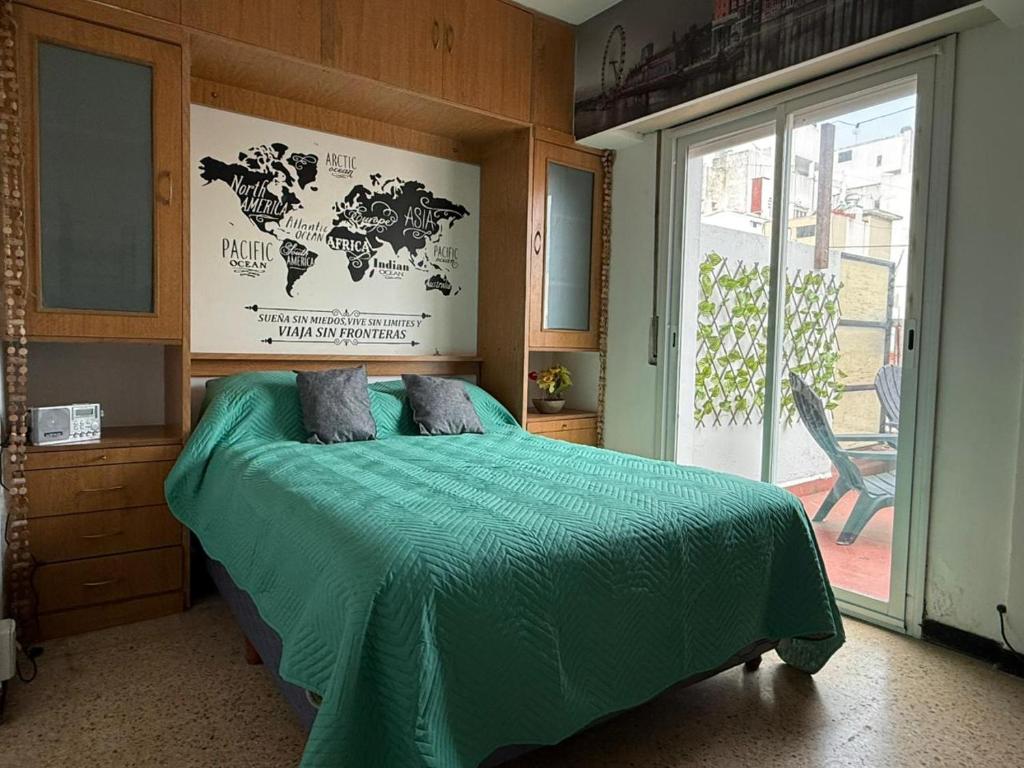 una camera con un letto verde e una grande finestra di Depto para 2 personas - Ubicación ideal en MDP a Mar del Plata