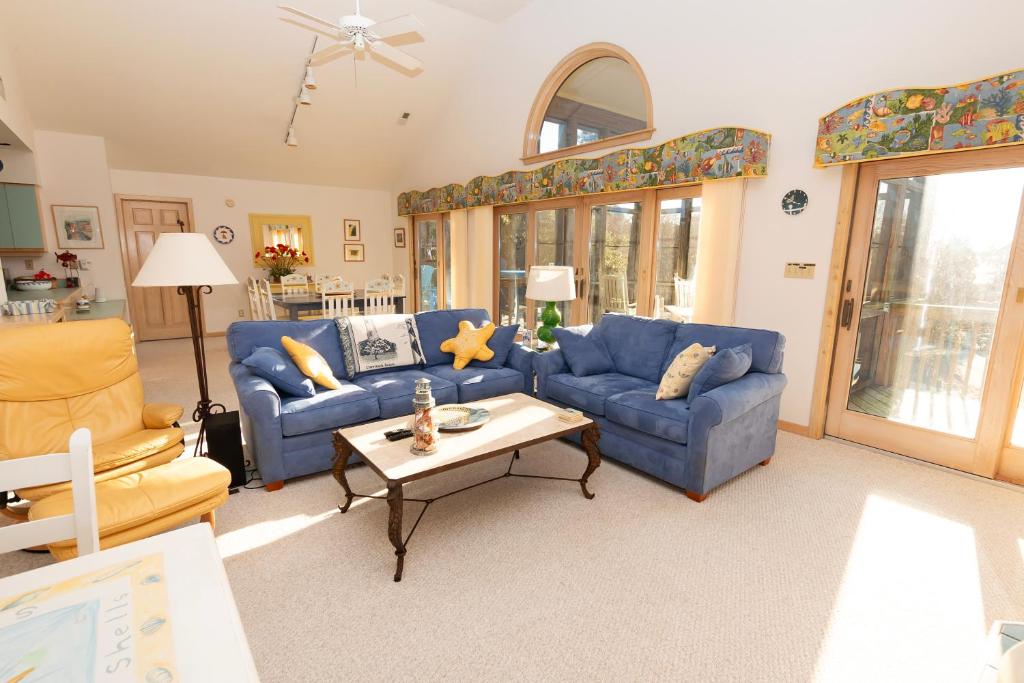 a living room with blue couches and a table at Soundside-Resort Amenities, Comm Pool-322, Out of Bounds in Corolla