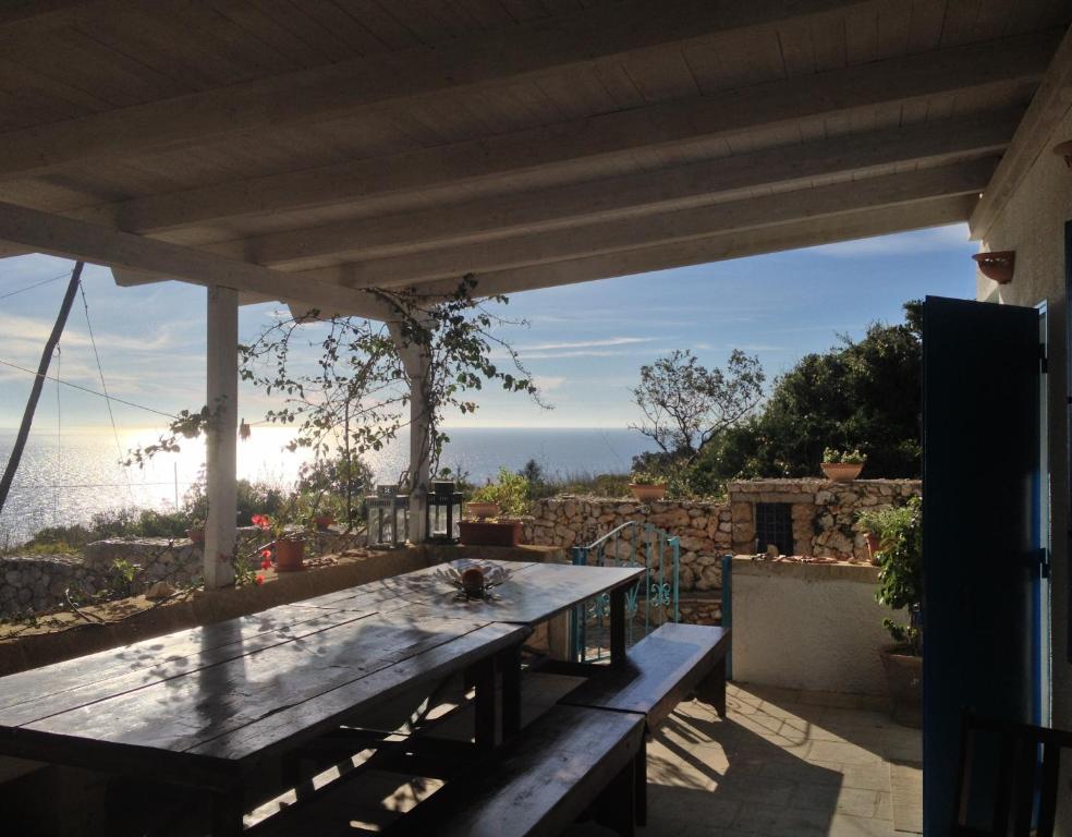 - une table en bois sur une terrasse avec vue sur l'océan dans l'établissement Azzurrosalento, à Marina Serra