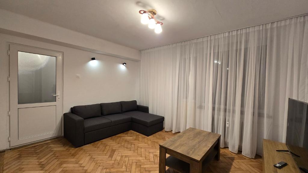una sala de estar con un sofá y una mesa en Shakespeare Central Apartment, en Craiova