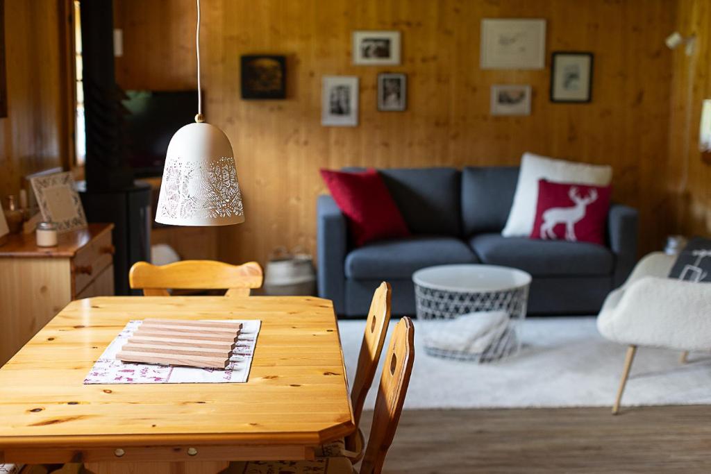 a table and chairs in a living room with a couch at Le Petit Mayen in Châtel-Saint-Denis