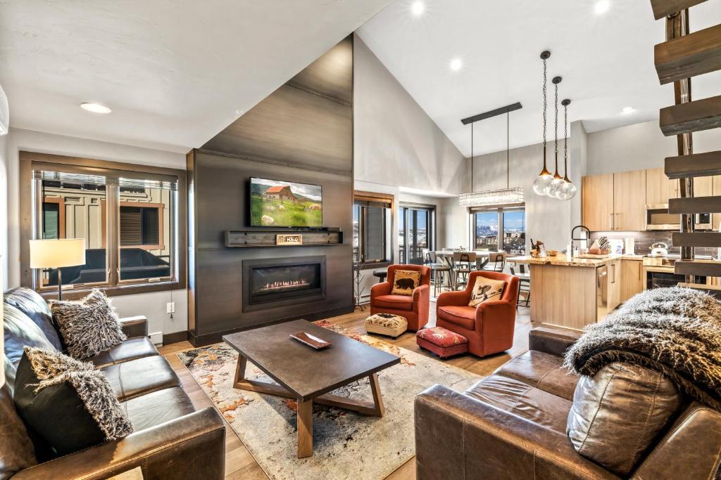a living room with a couch and a table at Bear Claw 405 - Luxury Condo, Ski-in Ski-out Access, Slope Views & Winter Shuttle! in Steamboat Springs