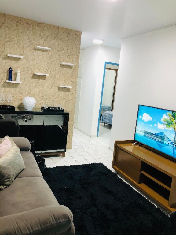 a living room with a couch and a flat screen tv at Home Confort in Garanhuns