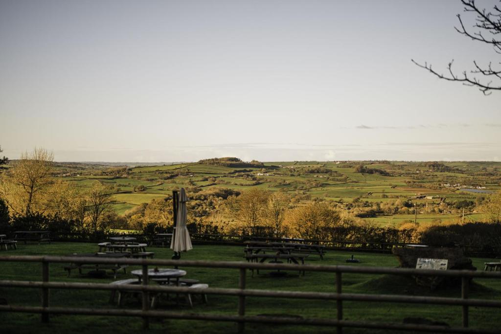 a group of picnic tables and an umbrella in a field at Winyard's Gap Inn in South Perrott
