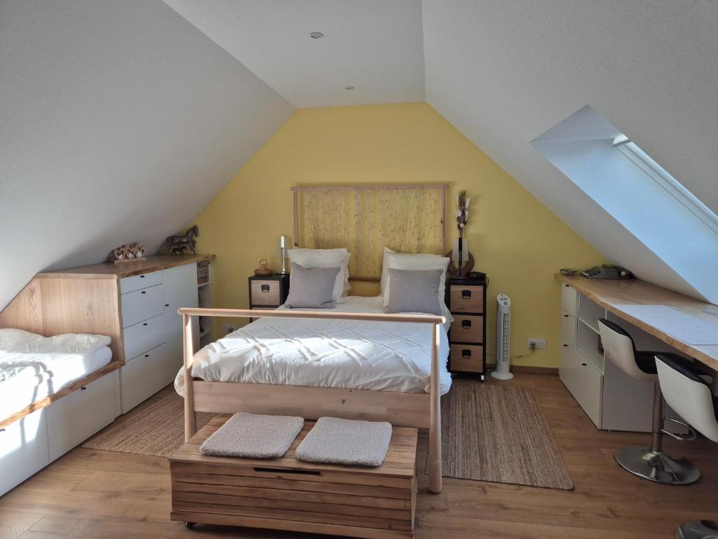 Dormitorio con cama y escritorio en el ático en Maison chaleureuse, en Griesheim-près-Molsheim